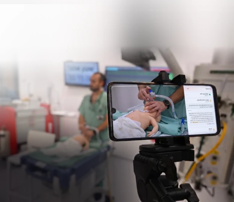 A phone on a tripod recording a neonatal resuscitation simulation